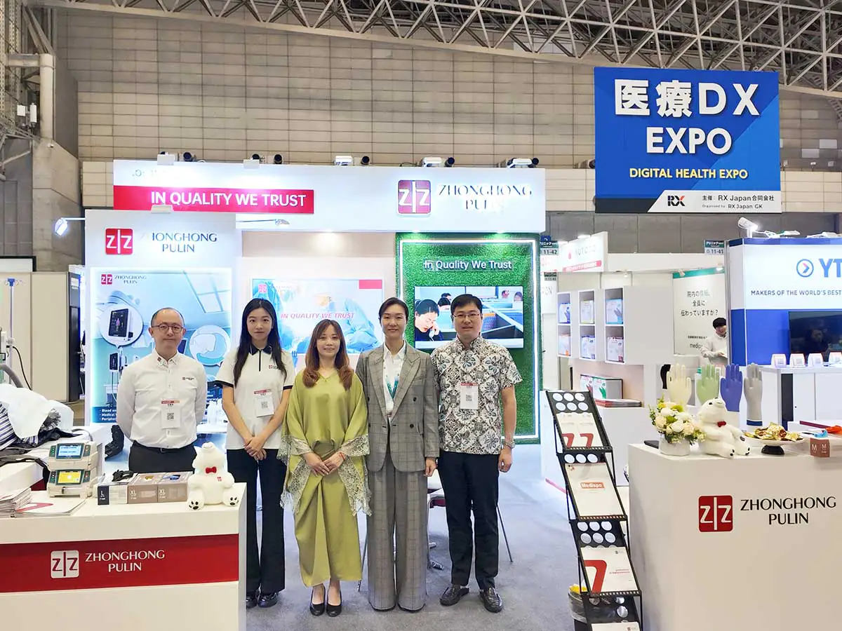 Five people posing at the Zhonghong Medical booth with medical equipment and Medispo glove displays at MEDICAL JAPAN TOKYO 2026