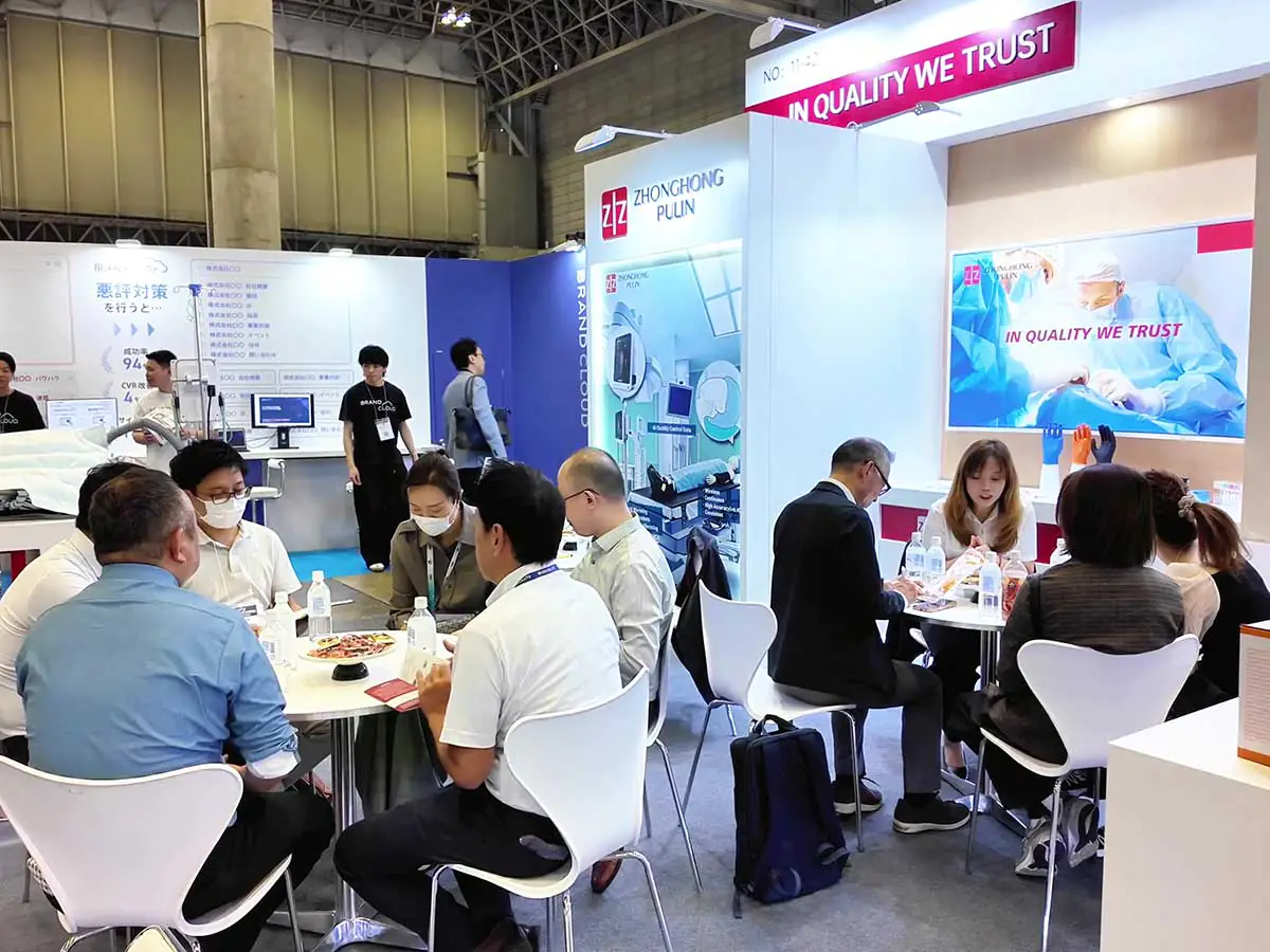 Visitors and exhibitors reviewing product materials at the Zhonghong Medical booth during MEDICAL JAPAN TOKYO 2026